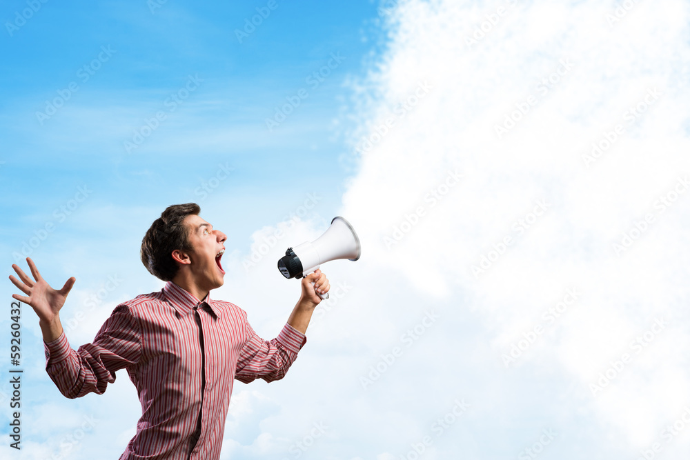 Portrait of a young man shouting using megaphone