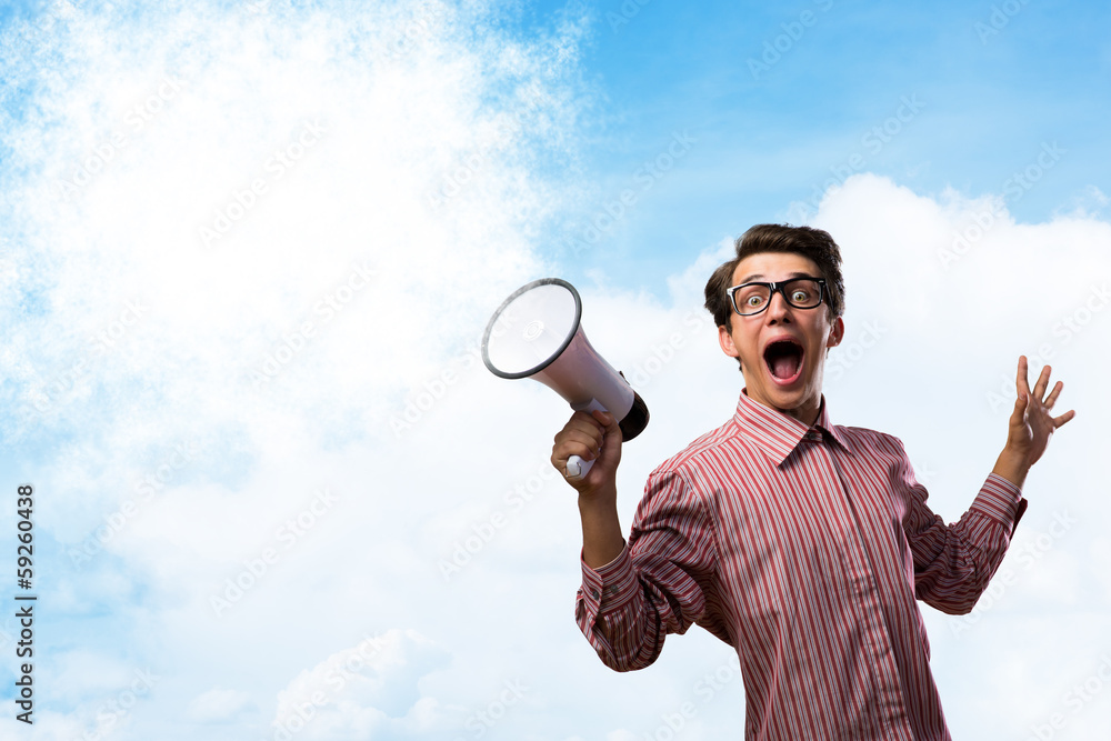 Portrait of a young man shouting using megaphone