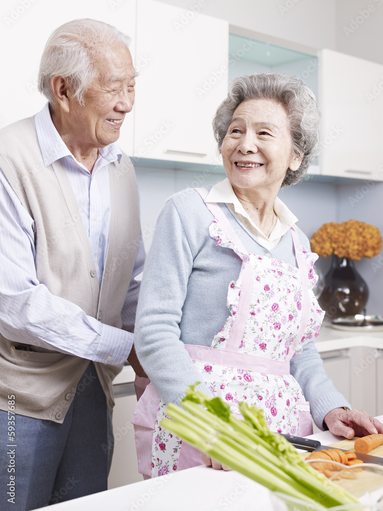 loving senior couple preparing meal in kitchen