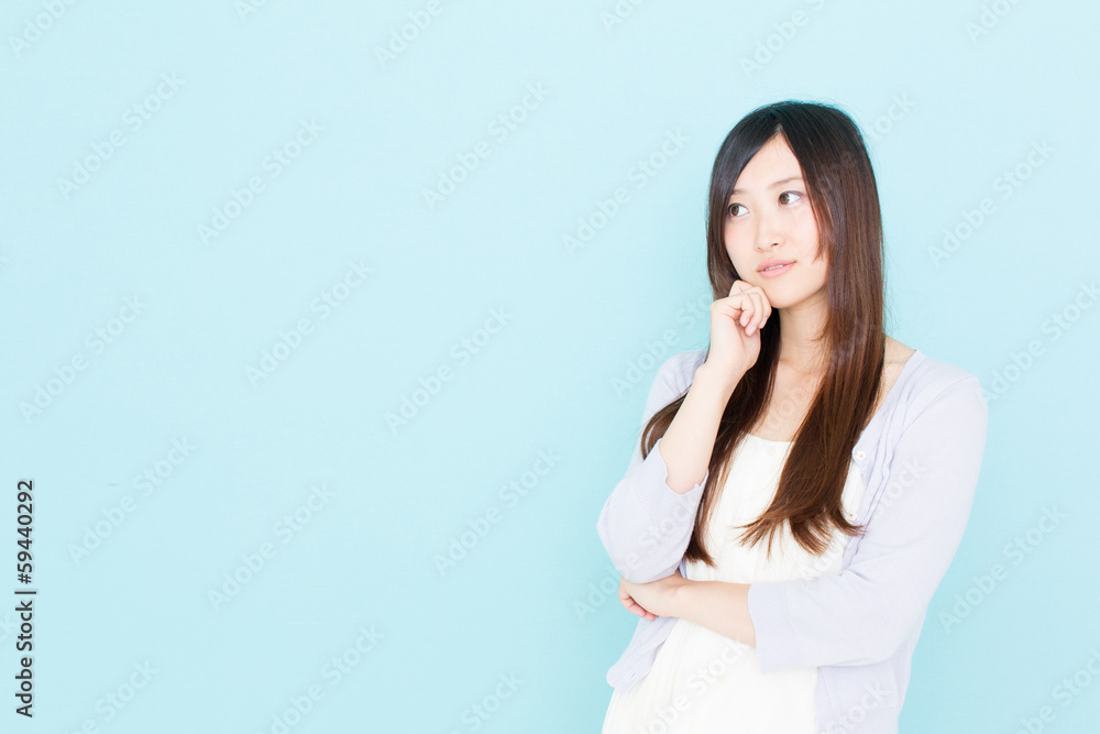 young asian woman thinking on blue background