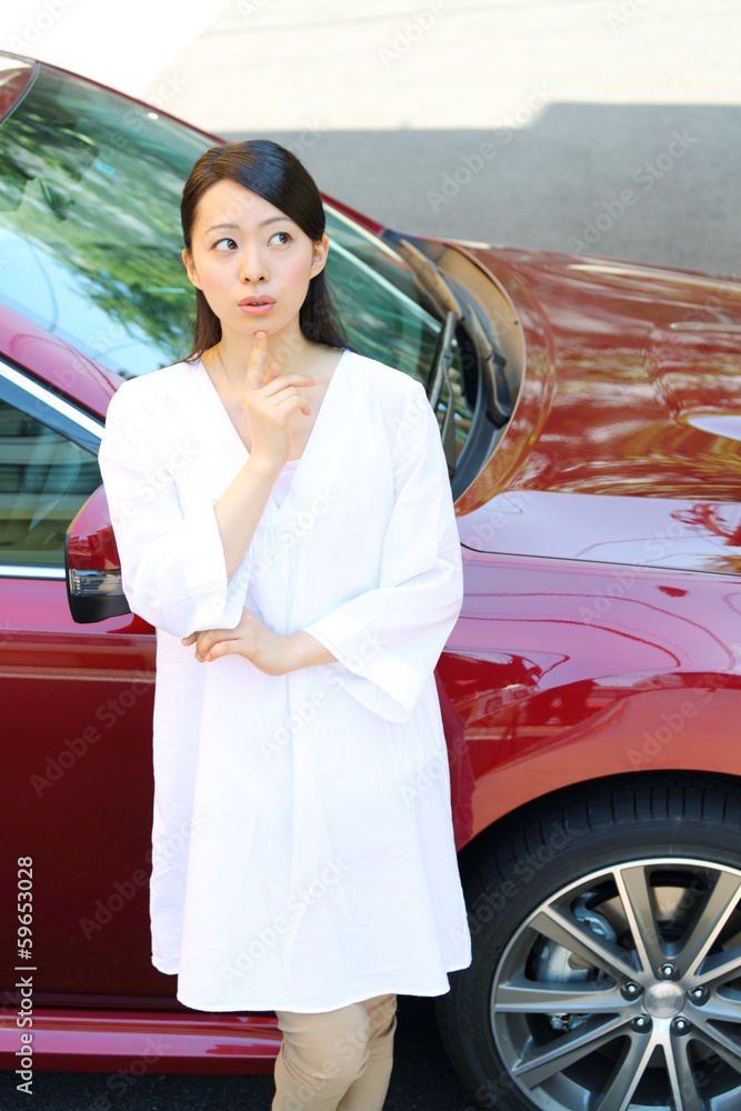 車の前で悩む女性