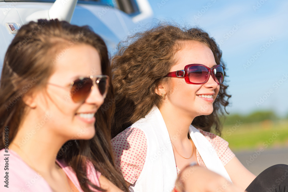 Two attractive young women wearing sunglasses