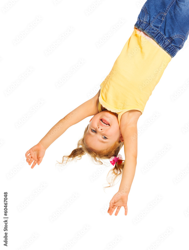 Happy little girl hanging isolated on white