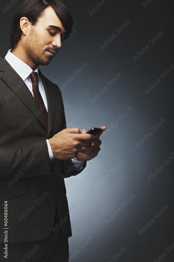 Businessman text messaging on a cell phone