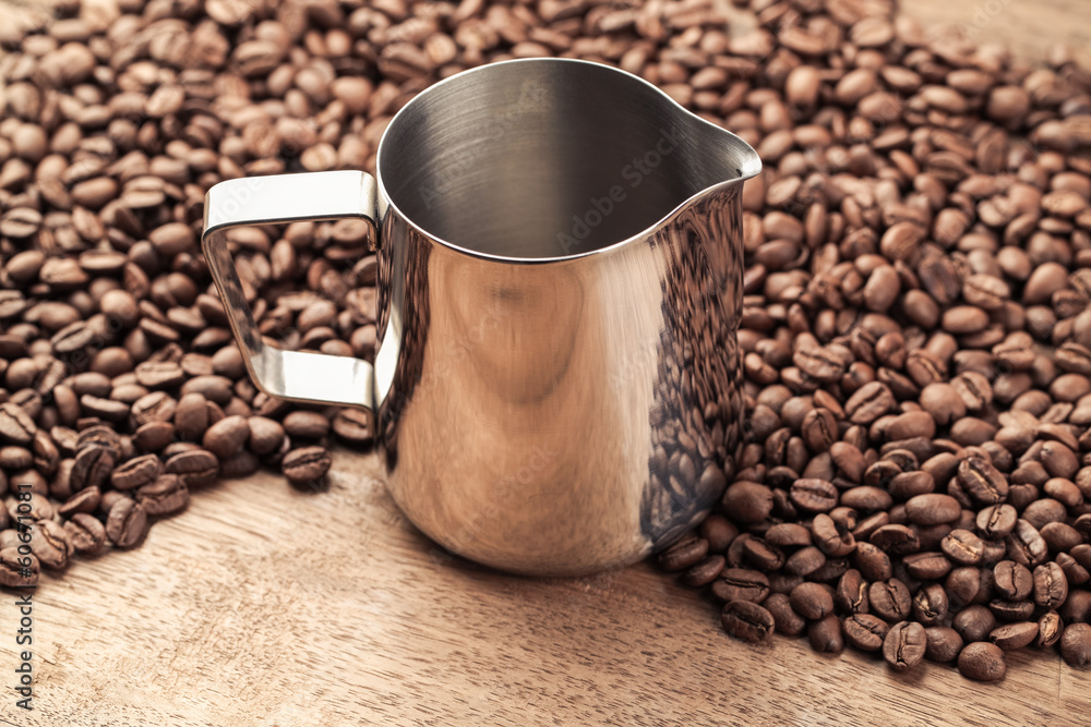 coffee pitcher and beans on old wooden table