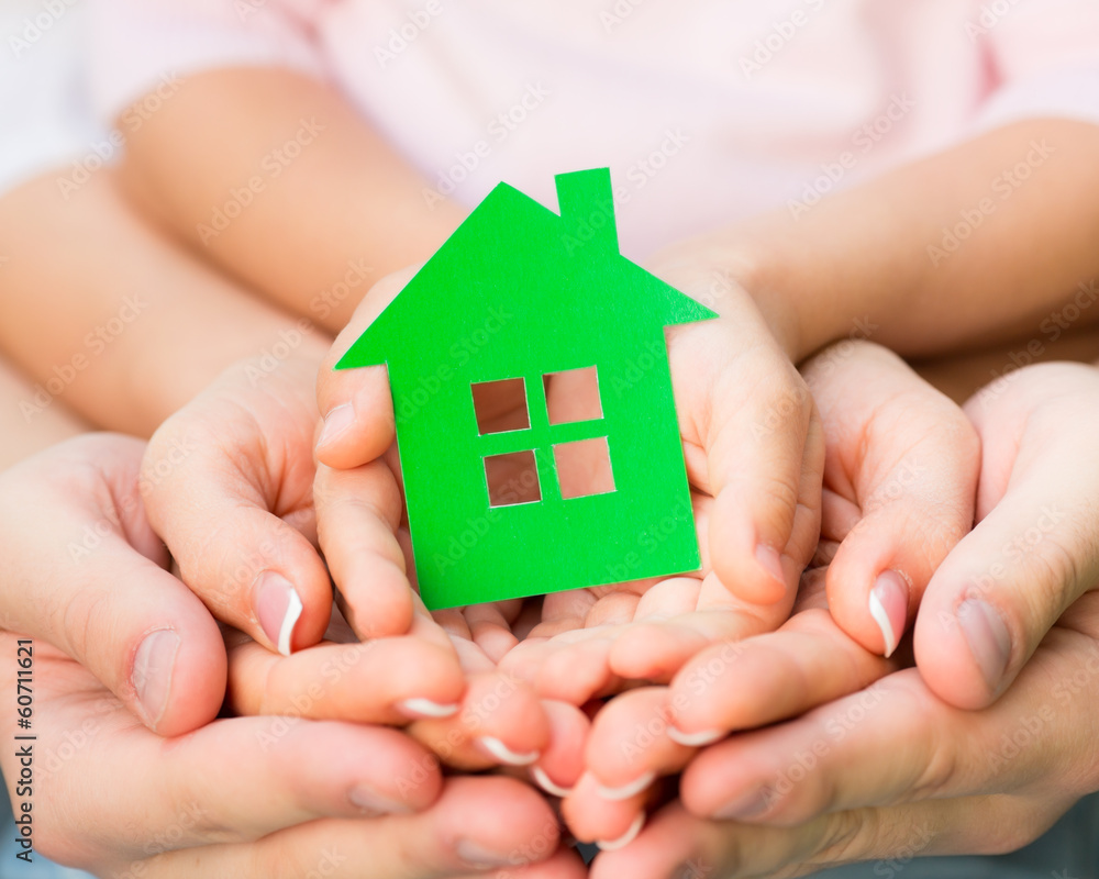 Family holding green paper house