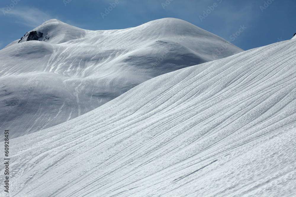 蓝天群山中的雪坡