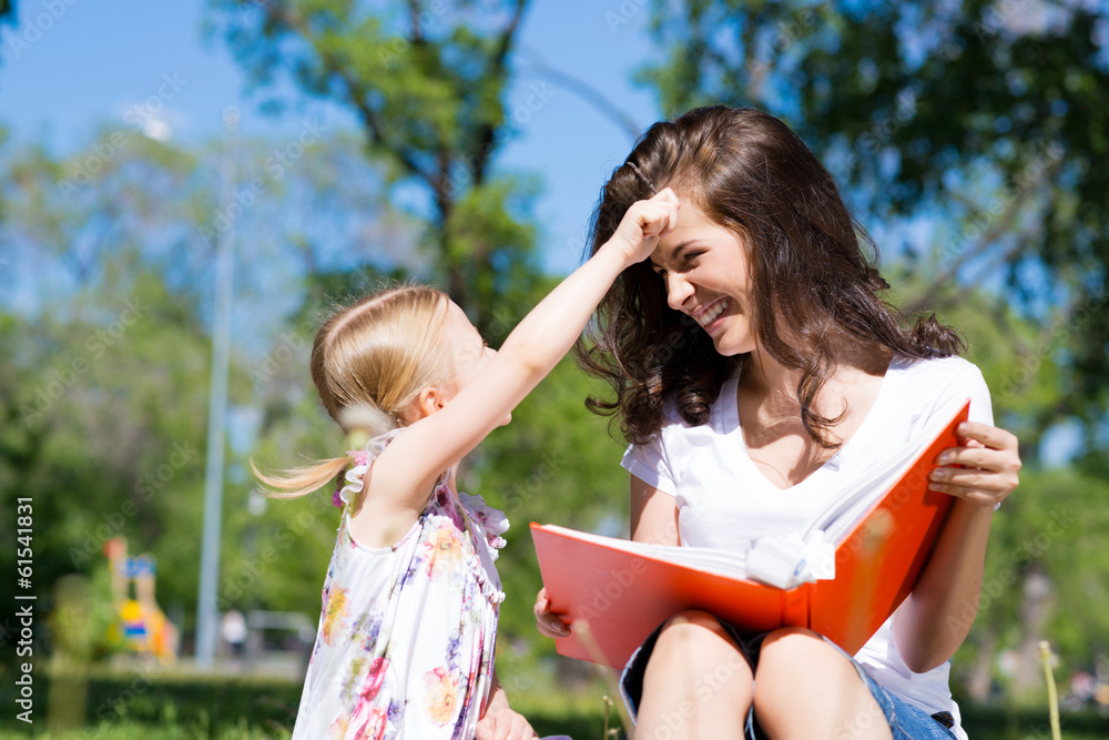 girl and a young woman reading a book together