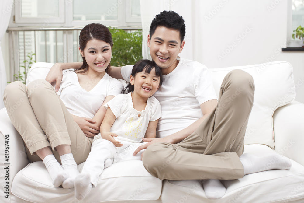 .Young family sitting in couch.