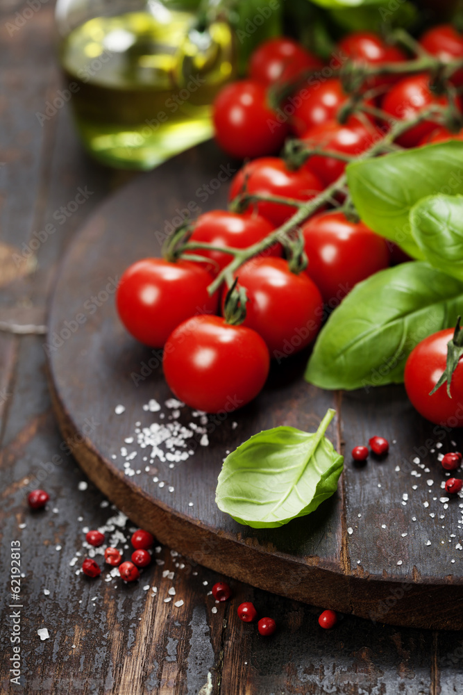 Tomatoes with basil on wooden table background