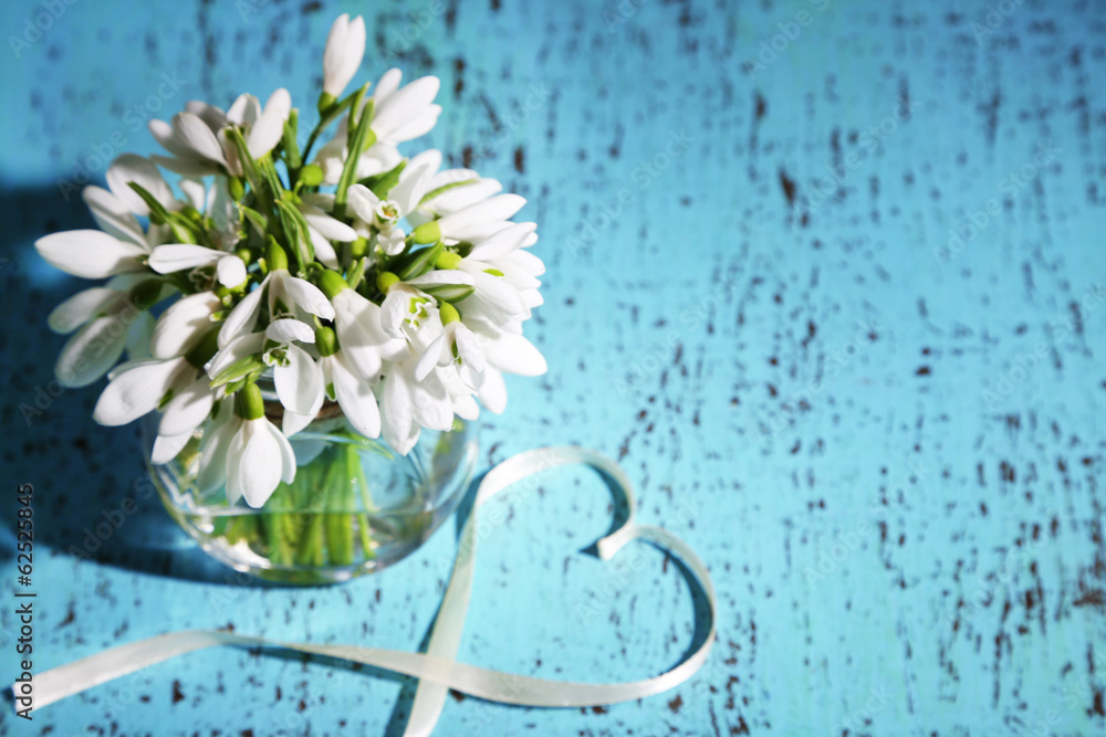 Bouquet of beautiful snowdrops on blue wooden background