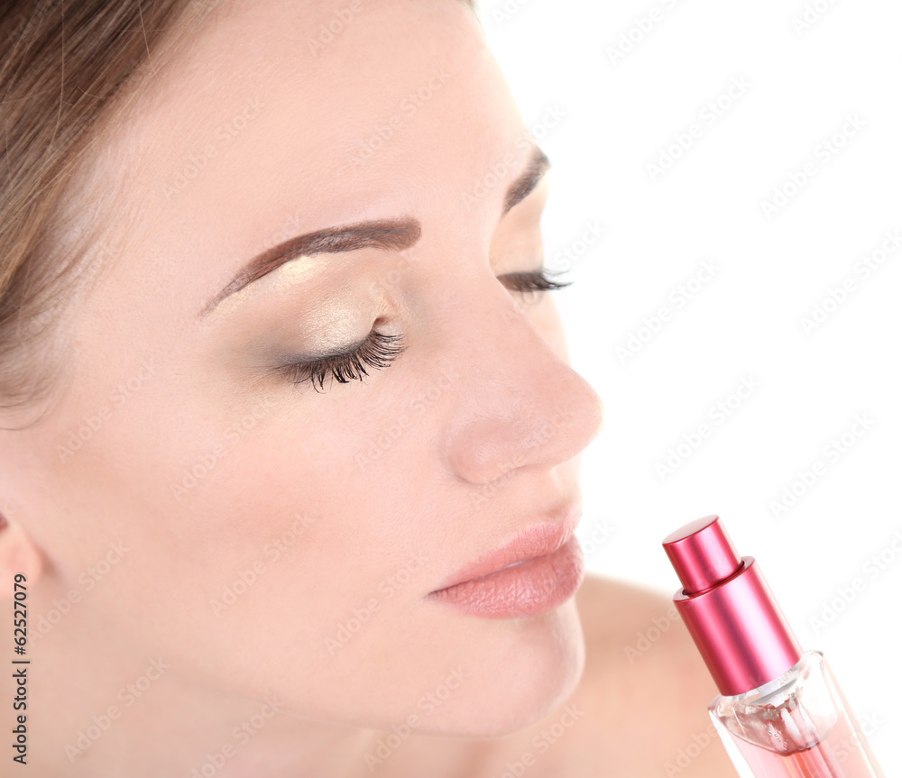 Young woman applying perfume isolated on white