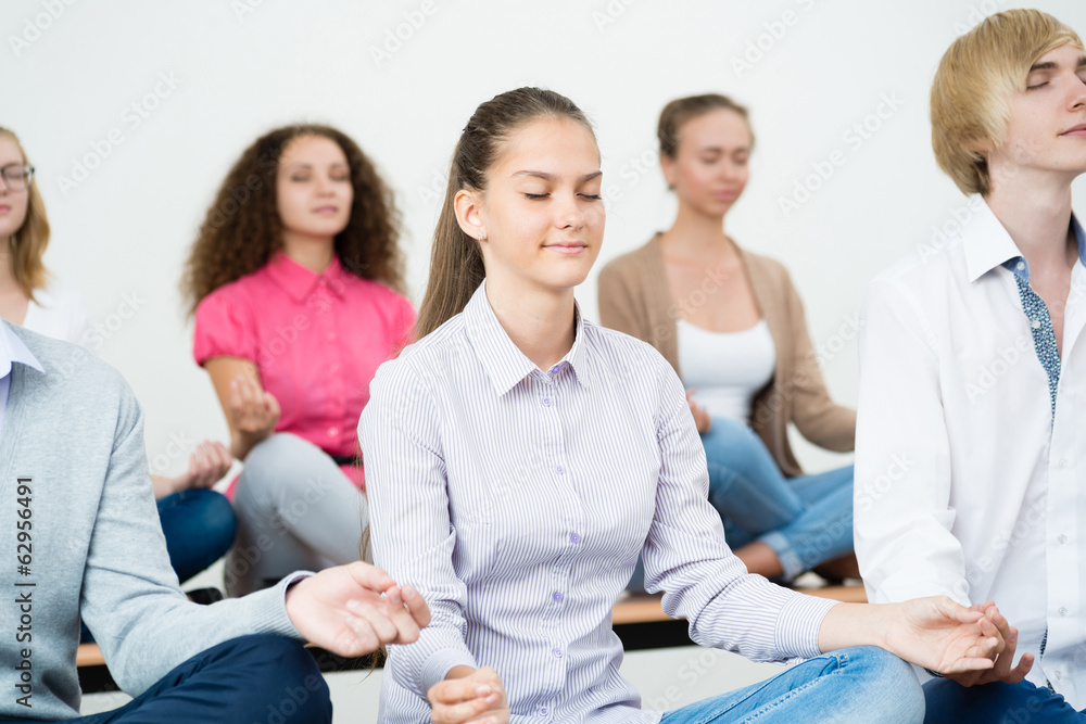 group of young people meditating