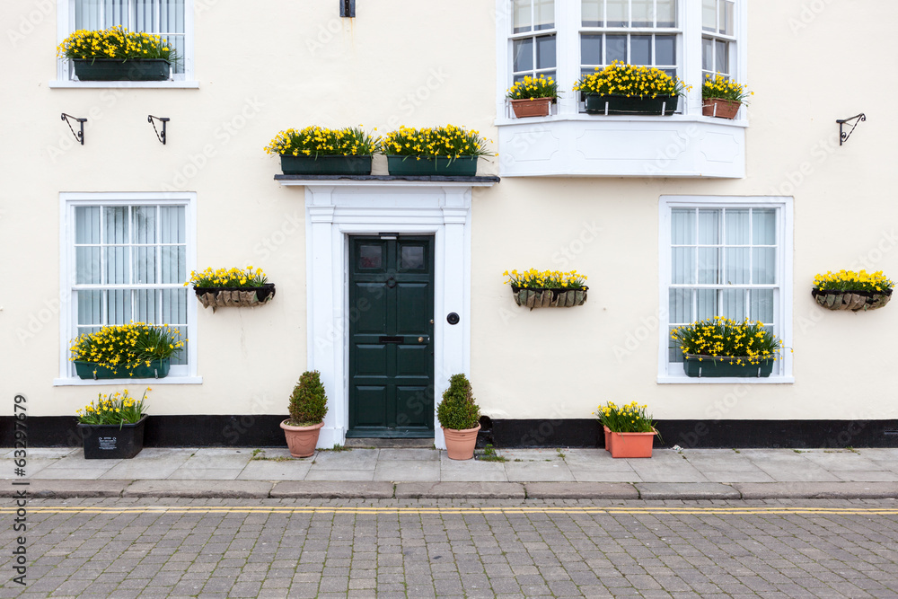 Pastel painted house with flowering baskets.