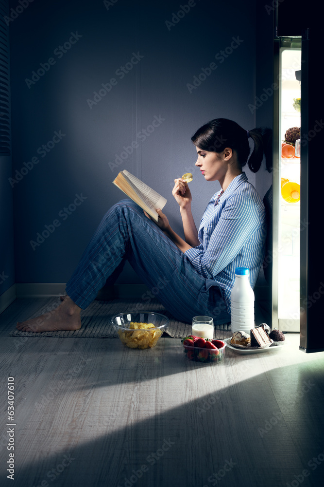 Sleepless woman reading in the kitchen