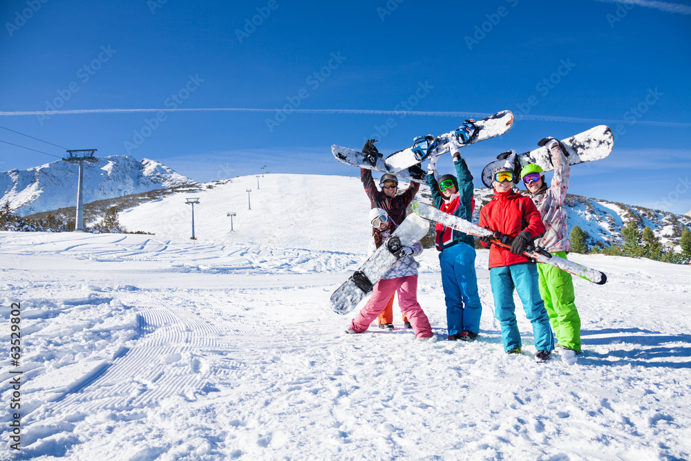 五个朋友一起拿着滑雪板和天空