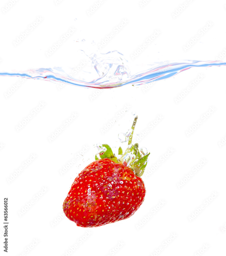 fresh strawberry dropped into water with splash