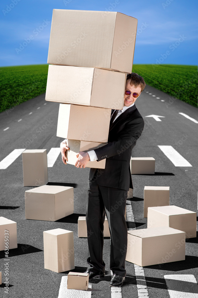 Business man holding carton boxes on the road