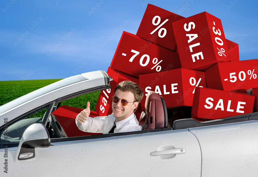 Smiling man in the car with baggage packed in boxes