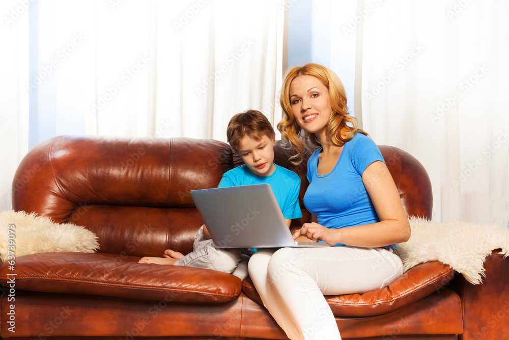 Child looking at laptop with smiling mum