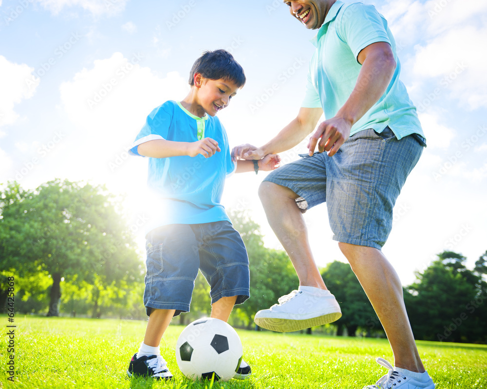 Little Boy Playing Soccer with his Father