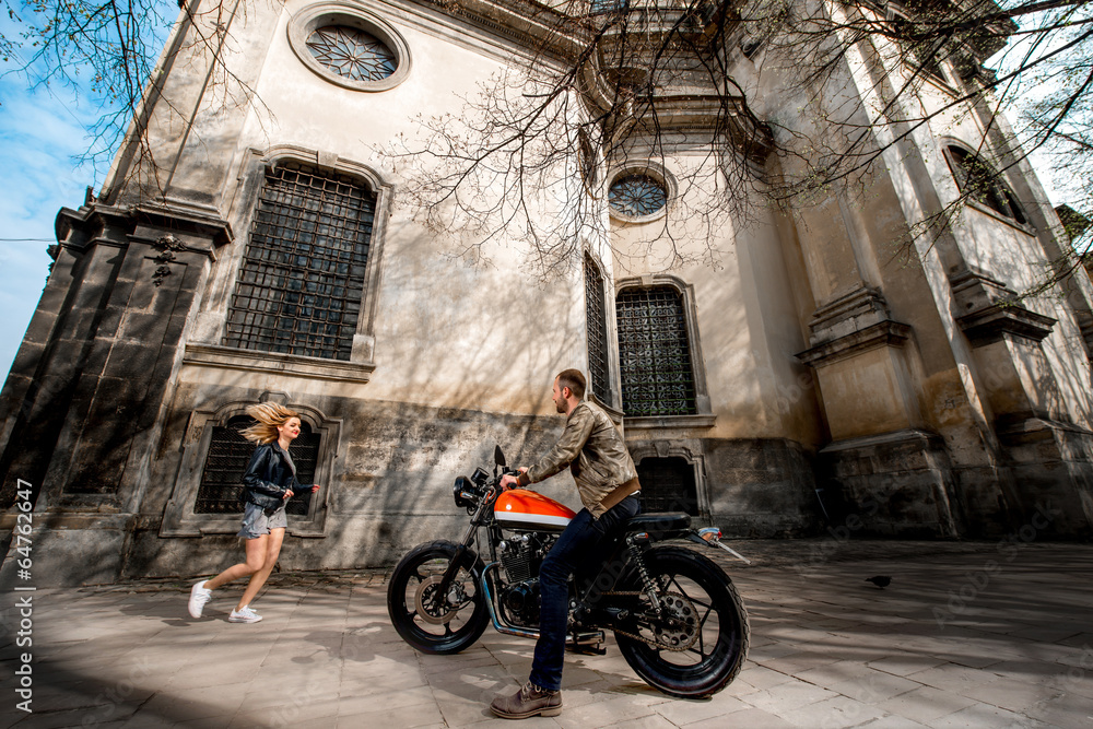 Girl running to her boyfriend sitting on the motorcycle