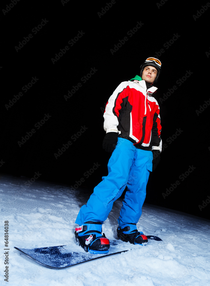 Young man on snowboard at night