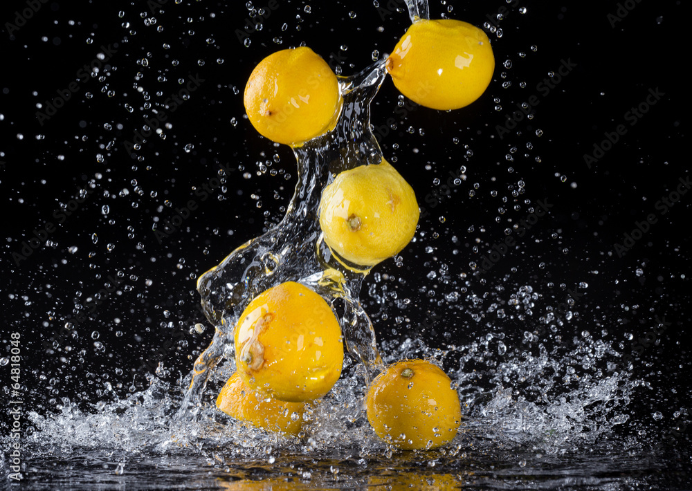 Lemons in water splash on black background