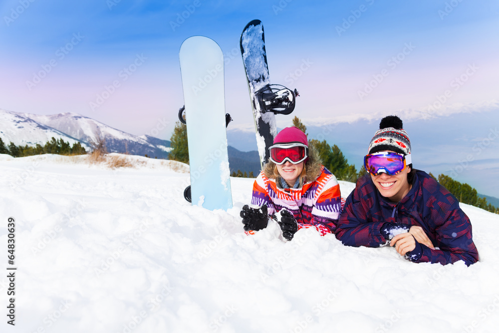 Man and woman in ski masks lying on the snow