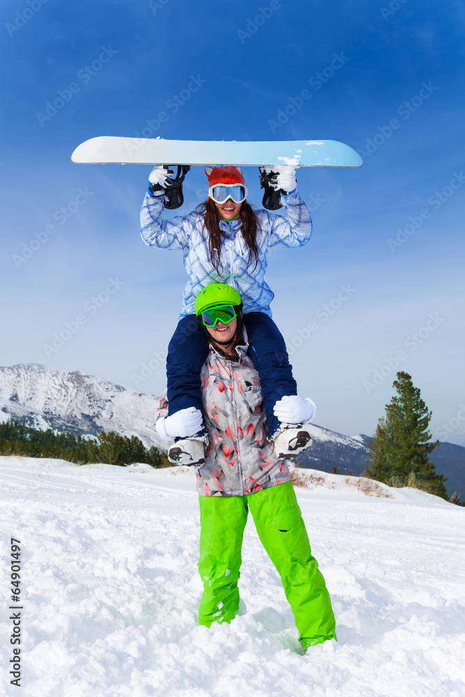 Snowboarder with girl sitting on his shoulders