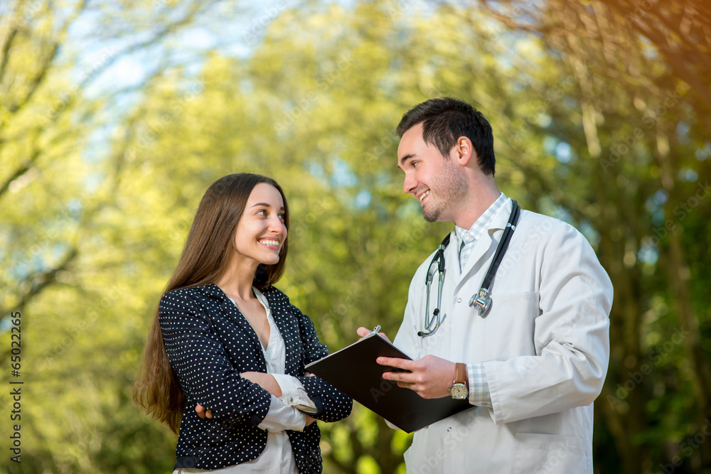 Young doctor with woman patient or assistant