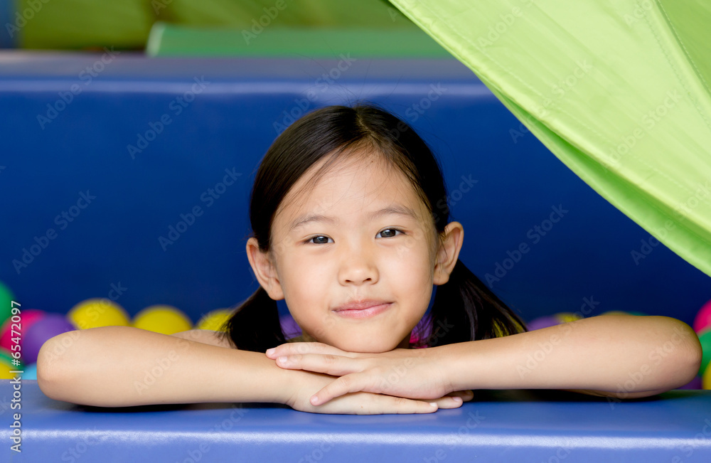 Happy Asian child playing at kindergarten with colorful balls