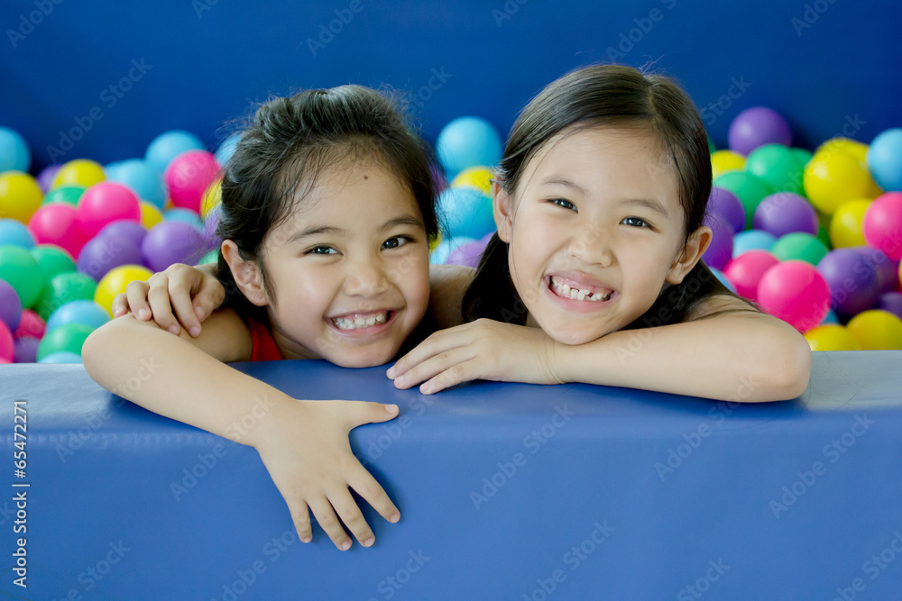 Happy Asian children playing at kindergarten with colorful balls