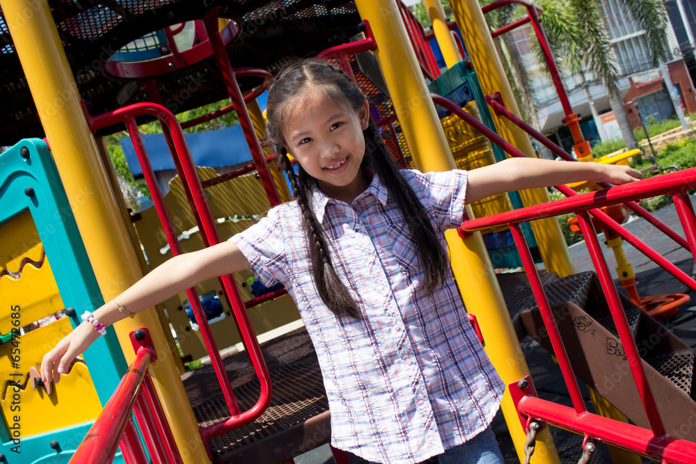 Cute beautiful smiling little girl on a playground