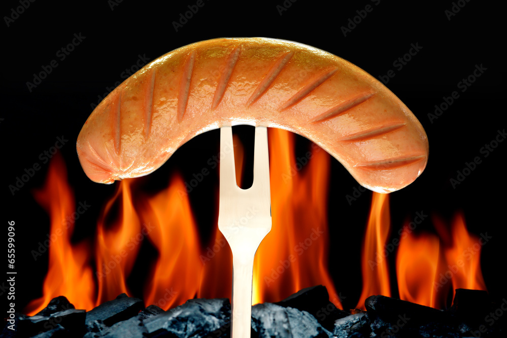 Grilled sausage on the flaming grill