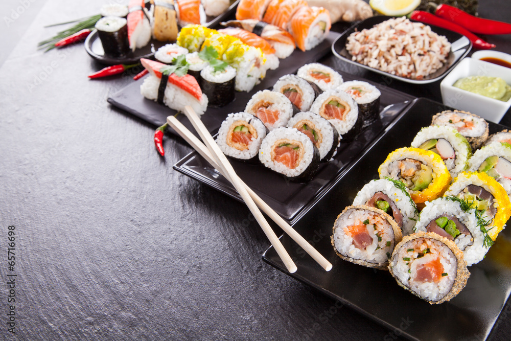 Delicious sushi pieces served on black stone