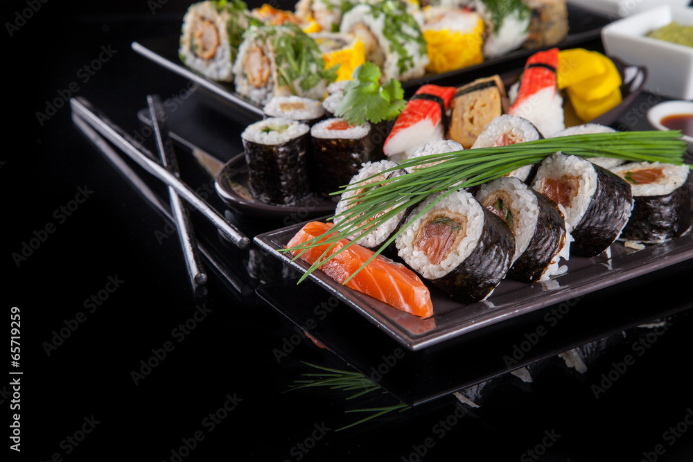 Delicious sushi pieces on black background