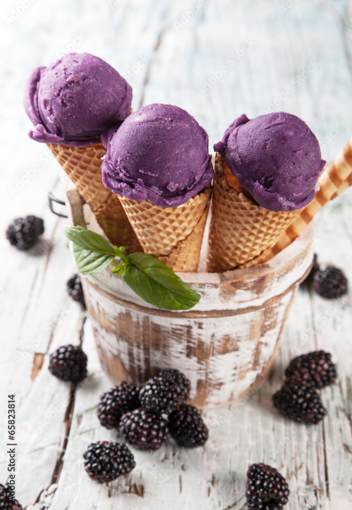 Blueberry fresh ice cream scoops in cones on wood