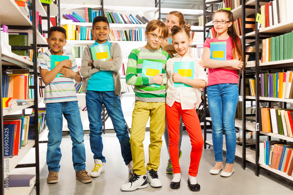 Children in library holding exercise books