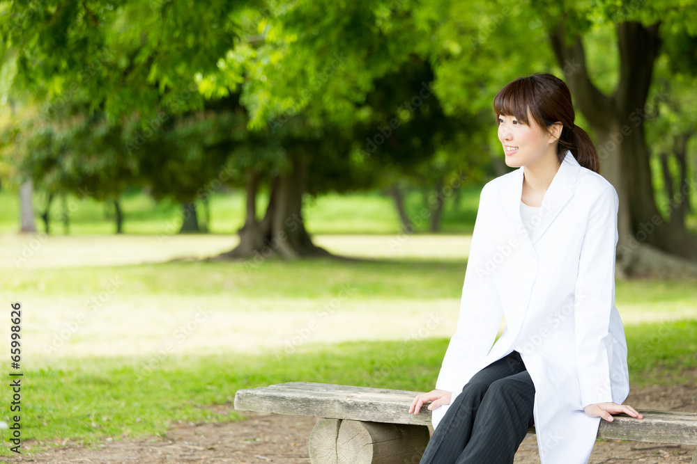 young asian doctor relaxing on green background