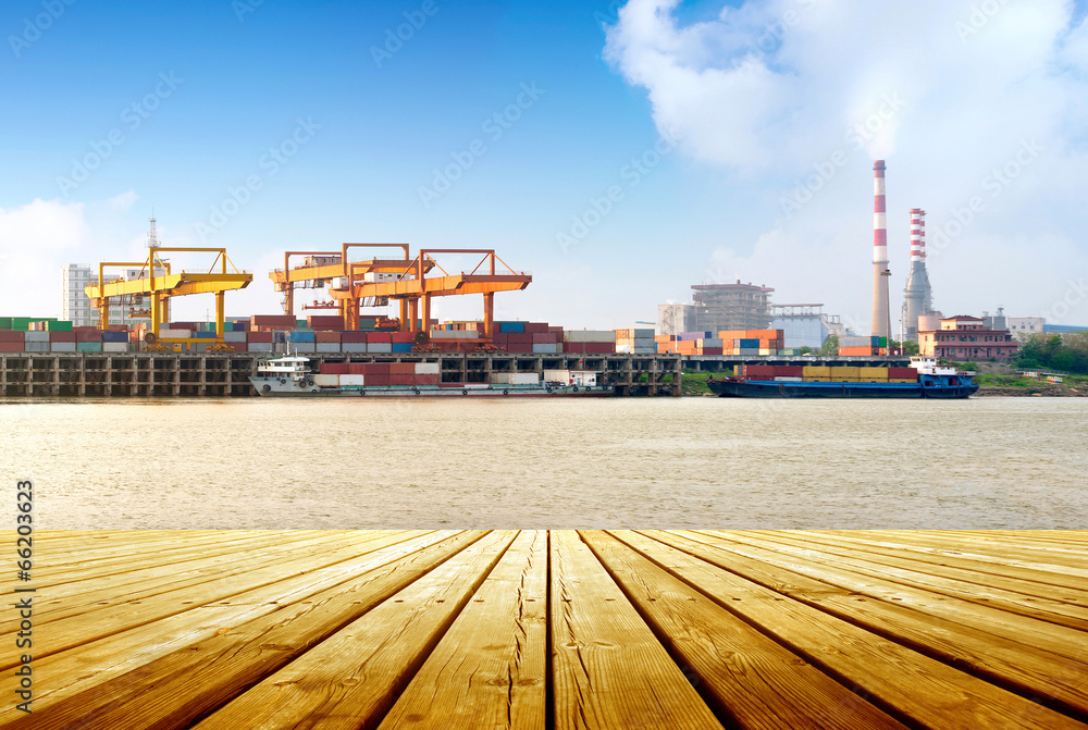 Container stacks and ship under crane bridge