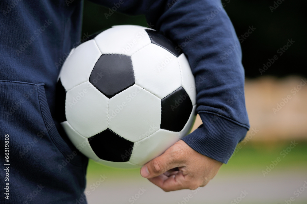 Hand holding soccer ball