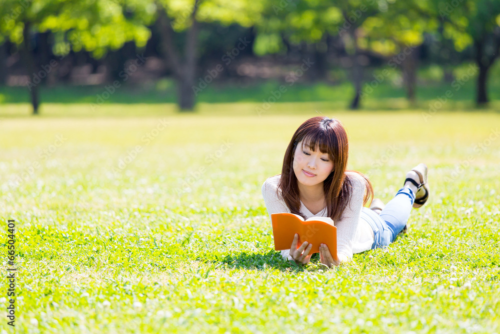 亚洲年轻女子在公园看书