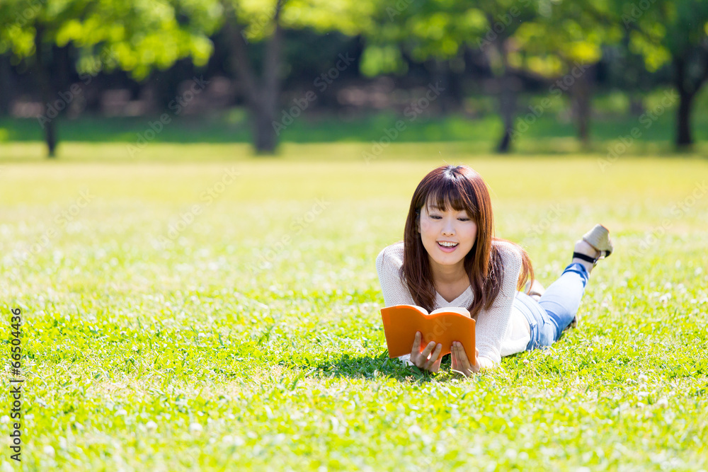 亚洲年轻女子在公园看书