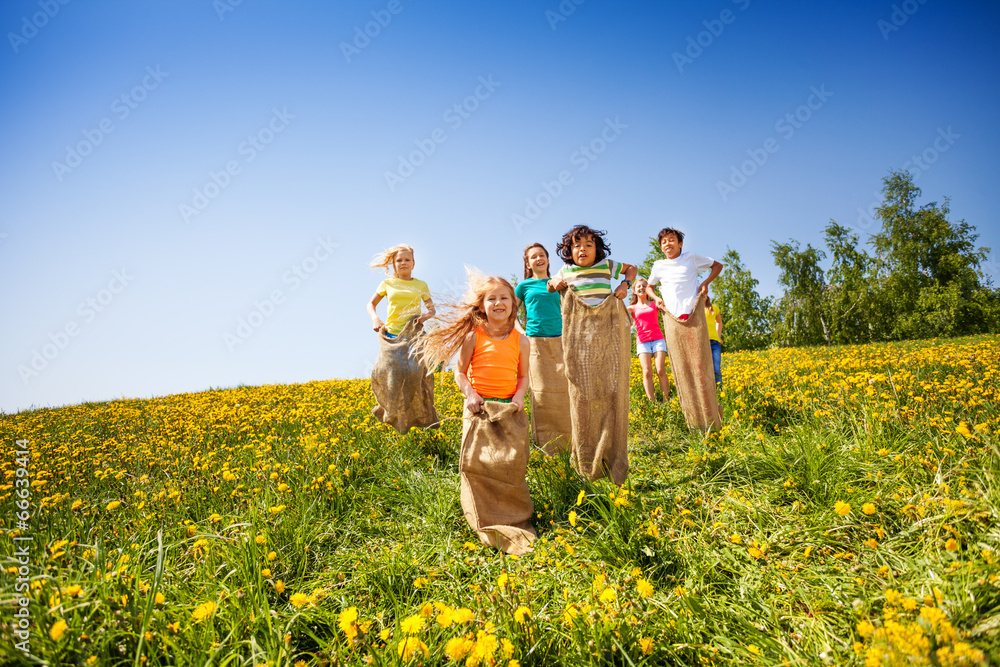 Children jump in sacks while playing together