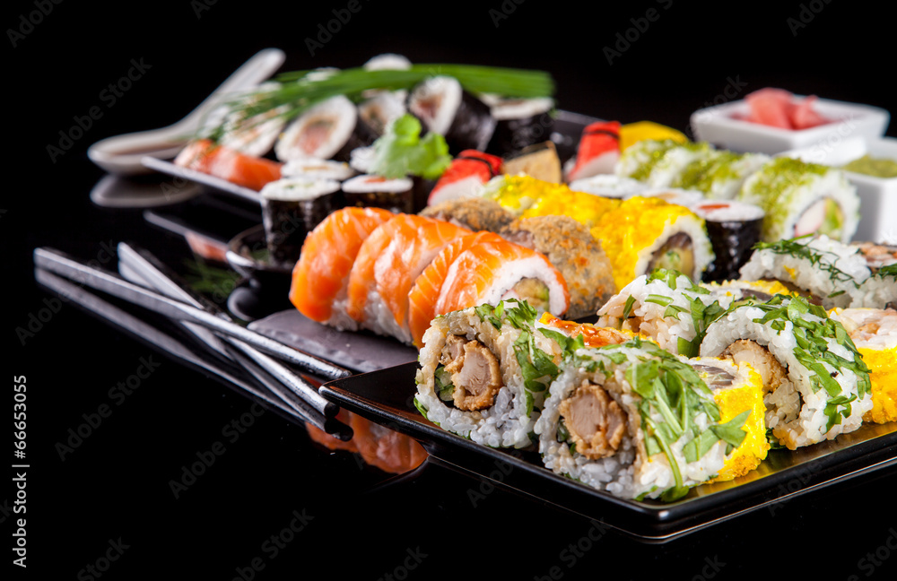 Delicious sushi pieces on black background