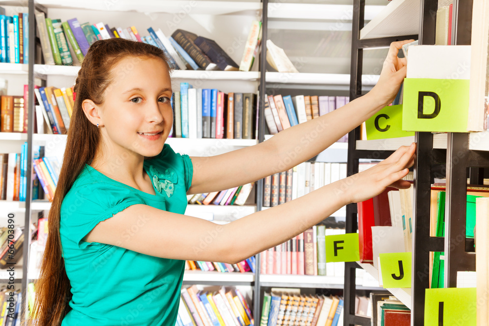 Girl with long hair searches book and smiles