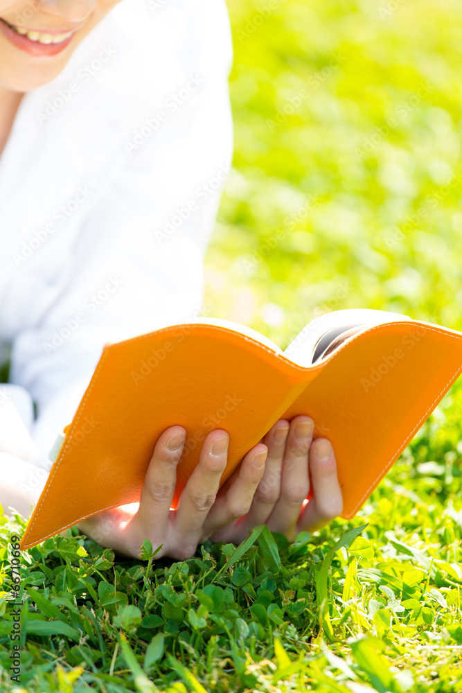 young asian woman reading book in the park