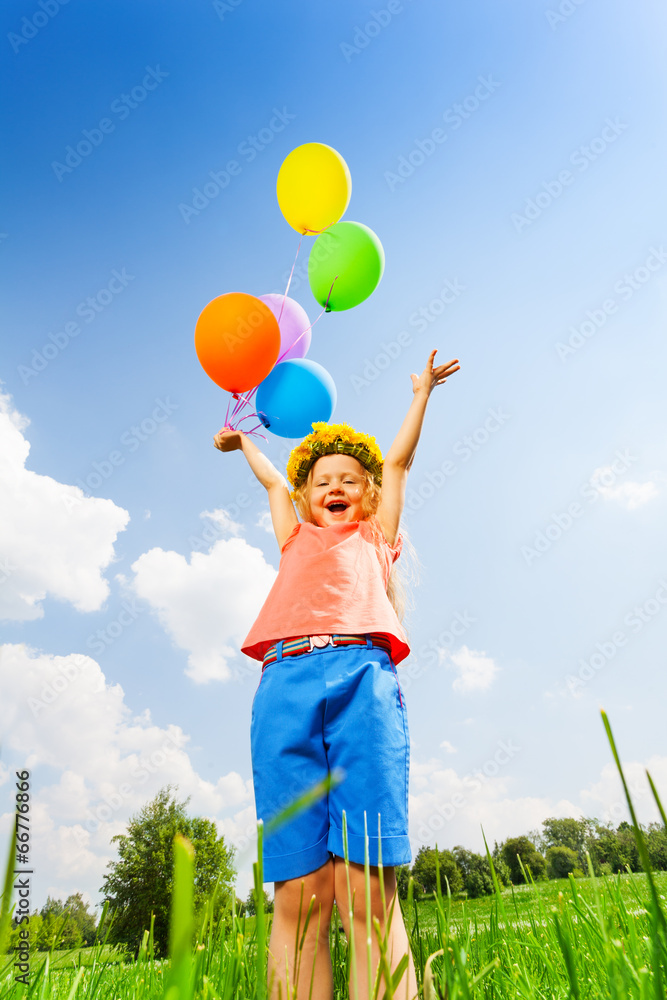 Happy girl with balloons wearing flower circlet