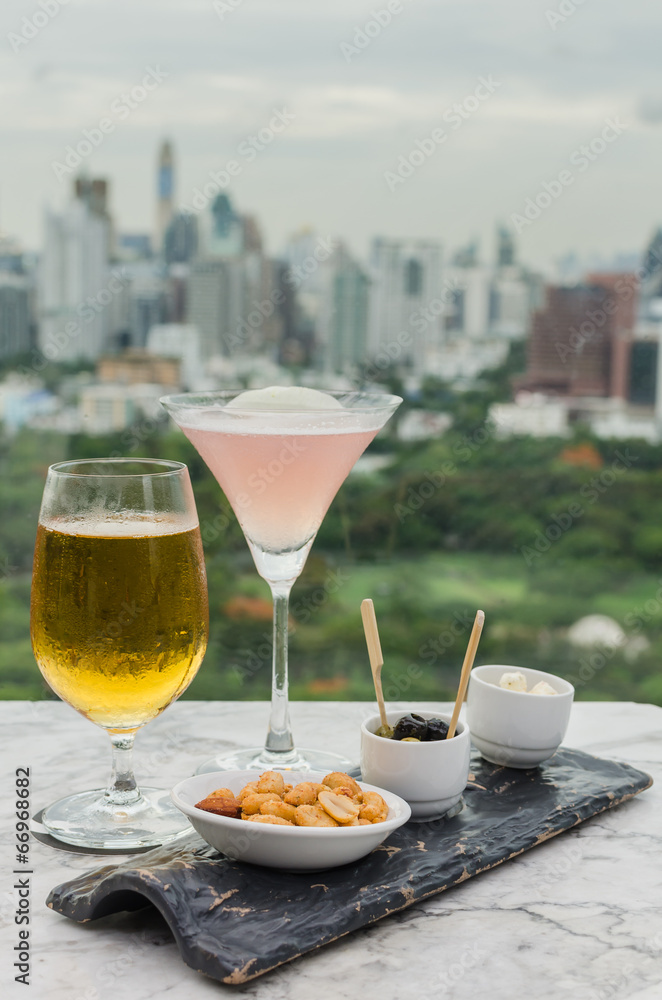 Glass of beer and cocktail with snack